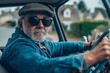 © zakiroff - Taxi driver in sunglasses, senior man, driving a vintage car, urban background, transportation, occupation concept