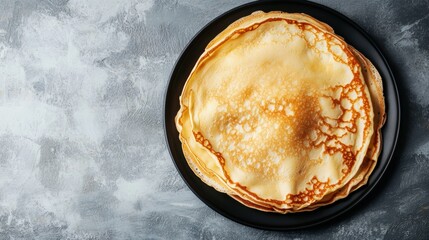 Poster - A stack of warm, golden crepes rests on a black plate, highlighting their delicate texture and inviting appearance on a gray surface. Generative AI