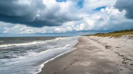 Poster - The sandy shore stretches along the beach, where waves softly lap against the coastline.