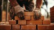 © aubriella - A close-up of a bricklayer carefully placing bricks, looking at the camera with concentration, Bricklaying site scene