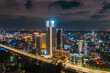 © AmazingAerialAgency - Aerial view of vibrant cityscape with illuminated buildings and bustling traffic, Westlands, Nairobi, Kenya.