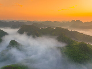 Orange sky and sea of clouds before sunrise. A peaceful, refreshing feeling. View of the hills surrounding Ba Quang, Ha Lang district, Cao Bang province, Vietnam