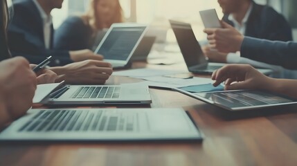 Wall Mural - Close-up of Business Professionals Working on Laptops and a Tablet