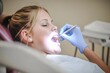© nupam - Woman getting a dental treatment at dentistry, Generative AI