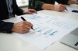 © Mediaphotos - Hands of two individuals engaged in reviewing project documents at workplace, focusing on details and notes for strategic planning and analysis