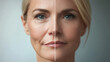 © Darya - A middle-aged woman's face is split in half, showcasing the differences between aging signs and rejuvenated skin following cosmetic procedures. facelift and facial surgery, botox, threads, fillers