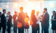 © IBEX.Media - A vibrant networking event with business professionals engaging in conversation, blurred figures creating a sense of motion and activity