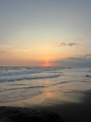 Serene sunset over a tranquil beach with gentle waves and a clear sky. Canggu, Bali