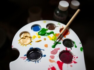 A palette of paint with a brush on it