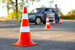 © New Africa - Examiner instructing student before exam at driving school test track, focus on traffic cone