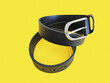© Mari - Women's leather black belt with metal buckle on yellow background