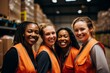 © Baba Images - Smiling portrait of a diverse group of female warehouse workers