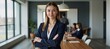 © Pixel Matrix - Young successful businesswoman stands confidently in a boardroom surrounded by colleagues engaged in discussion