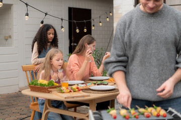 Grandfather, parents, and the teenage girls are all having dinner together at home