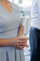 a lighted candle in the hands of people at the holiday