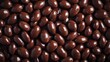 © Eric - A seamless spread of chocolate-covered almonds, tightly arranged to fill the entire frame with their rich, glossy texture and dark tones.