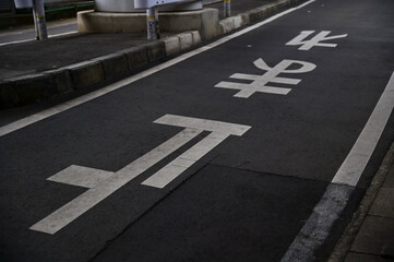 The letters on the stop sign written on the road surface of the japan roadway. Japanese street signs. Translation: Japanese Kanji letter telling car drivers to stop.