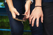 © CamPen2000/peopleimages.com - Hands, music and phone with couple outdoor for listening, sharing or streaming audio closeup. Earphones, radio or sound with man and woman sitting together to enjoy playlist or song for bonding
