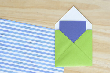 Canvas Print - square green envelope with blue card on wood and scrapbooking paper with stripes