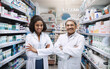 © Koegelenberg Coop/peopleimages.com - Portrait, pharmacy and mature man with woman in team with mentor, intern and arms crossed in drug store. Pharmaceutical, healthcare service and people with medical experience, retail and medicine