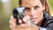 © SERHII - Intense woman aiming handgun outdoors close-up