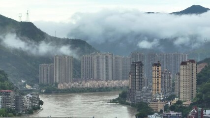 Wall Mural - riverfront high-rise buildings surrounded by mountain and fog in Qingtian town, Zhejiang, China