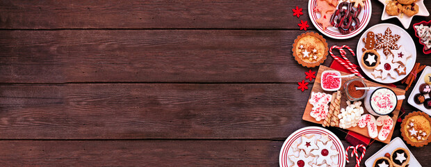 Poster - Christmas holiday cookies and desserts side border. Overhead view on a dark wood banner background. Cookies, tarts, chocolates and hot chocolate tray.