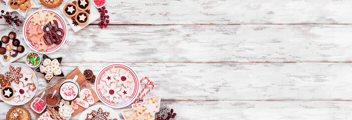 Poster - Christmas holiday cookies and desserts corner border. Overhead view on a white wood banner background. Cookies, tarts, chocolates and hot chocolate tray.