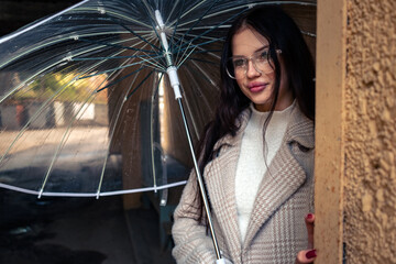 A girl with an umbrella is walking in rainy weather.