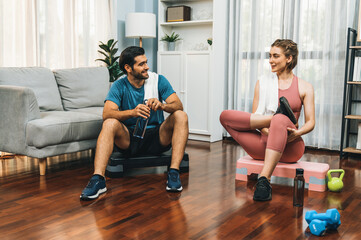 Athletic body and sporty young couple or workout buddy in sportswear warmup or resting after finishing in home workout exercise at gaiety home exercise and healthy lifestyle concept.