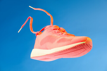 Sticker - One stylish bright sneaker in air against light blue background