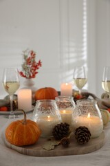 Wall Mural - Burning candles and autumn decor on table indoors