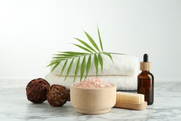 Canvas Print - Spa treatment. Towels, sea salt, brush, bottle of serum and palm leaf on white marble table