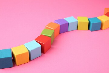 Poster - Many wooden colorful cubes on pink background