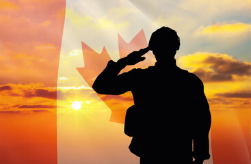 Silhouette of a soldier with a background of the Canada flag and a sunset or sunrise. Concept of national holidays. Commemoration Day.