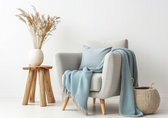 Stylish and comfortable living room interior with a cozy armchair, blanket, a wooden stool, and a wicker basket. Minimalist Scandinavian home decor