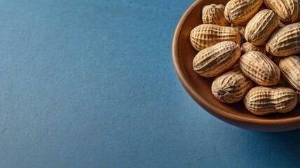 Peanuts in shells on a blue background, featuring ample copy space.