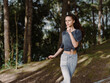 © SHOTPRIME STUDIO - Young woman jogging in a forest, wearing athletic clothes and a determined expression, embodying health and fitness amidst nature Exercise and wellness concept