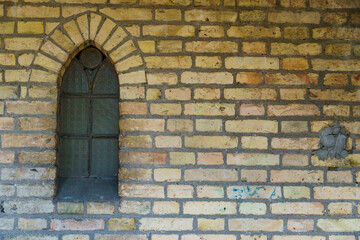 The arched stained glass window in the church. The exterior of the old church.