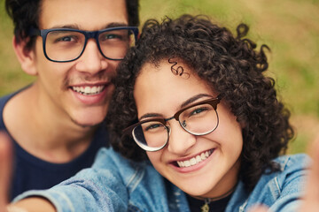 Couple, portrait and smile with selfie in park for bonding, profile picture update or social media post. Teenager, people and glasses with photography in nature for happy memory and holiday adventure