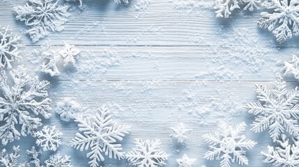 Winter background featuring a frame of snowflakes on a bright light grey rustic wooden texture providing ample space for text from a top view ideal for a panoramic banner