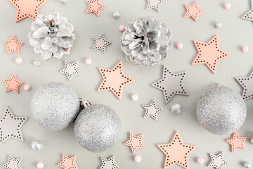 Beautiful composition with Christmas balls, decorative stars, beads and silver cones on grey background, closeup