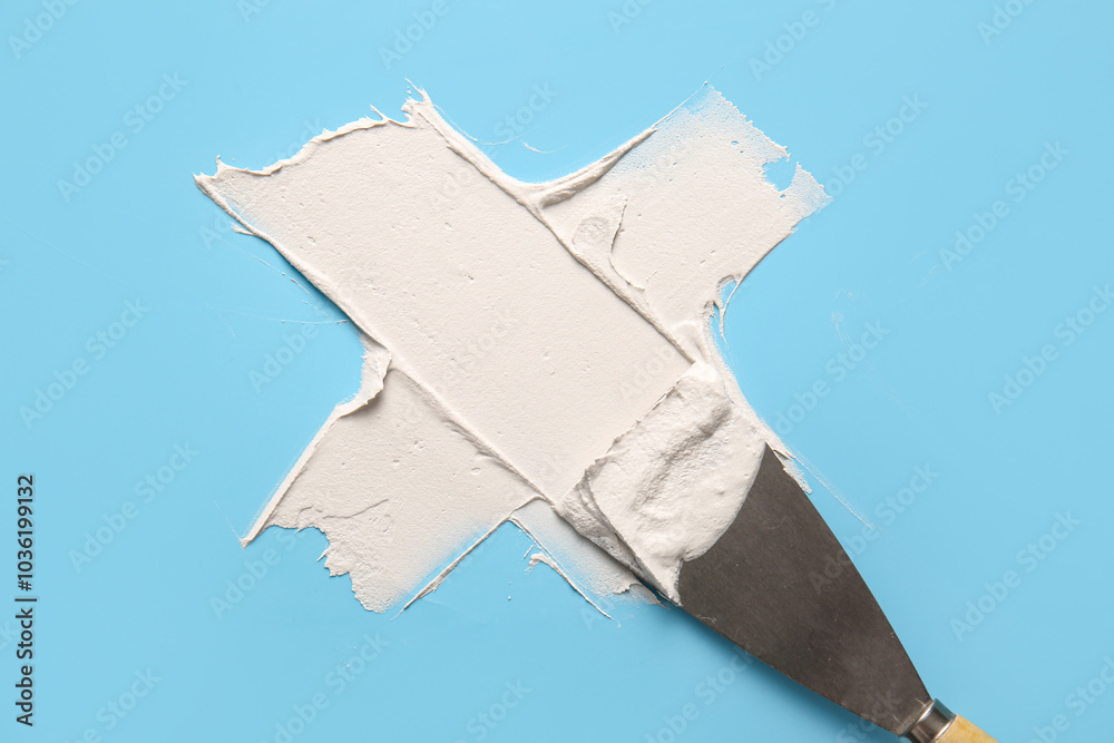 Knife with putty on blue background