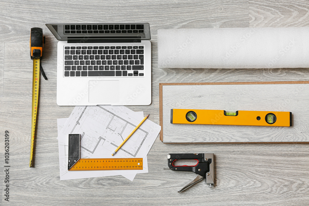 Tools, laptop, house project and laminate boards on floor