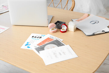 Wedding planner's table with laptop, rings and invitations in office