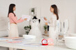 © Pixel-Shot - Boxes with rings on table against female wedding planners working in office, closeup