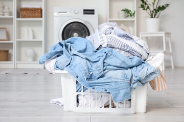 Wall Mural - Basket full of dirty clothes in light laundry room, closeup