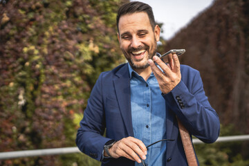 businessman stand on the terrace and left voice mail on mobile phone