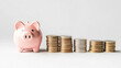 © Clipart Collectors - A piggy bank standing next to increasing stacks of coins, symbolizing savings growth