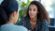 © Aurora - A woman attentively listens and speaks during a serious conversation with a colleague in a professional, well-lit office setting, emphasizing communication and focus.
